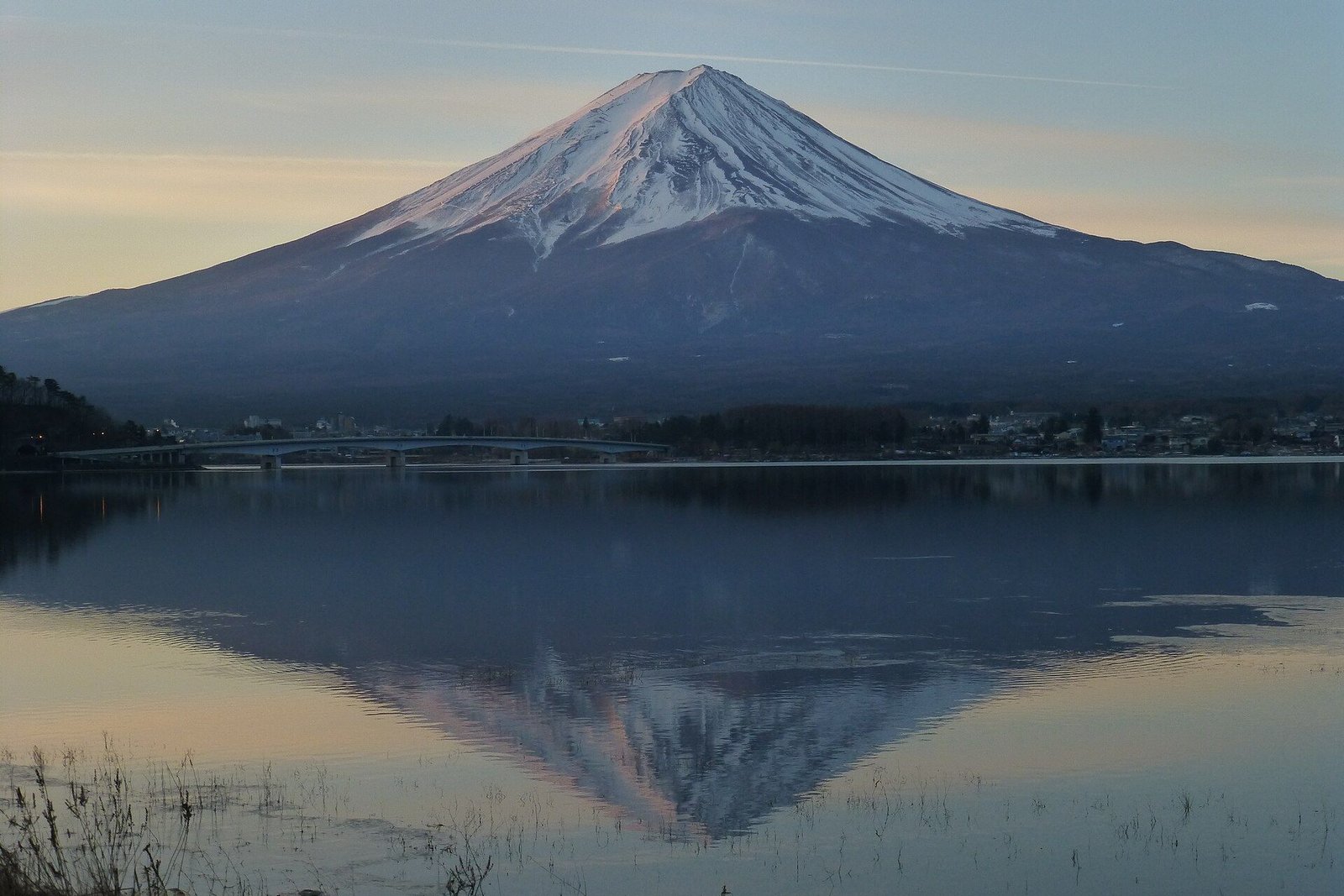Mount Fuji reflected in the still water of Lake Kawaguchi at first light